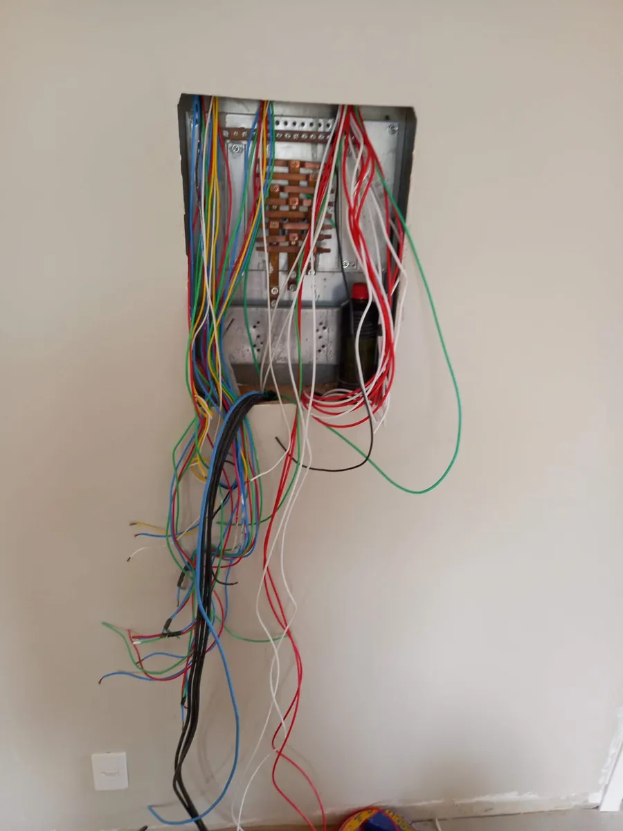 Quadro elétrico desorganizado, com fios soltos e sem padronização, antes do serviço da MCD Soluções Elétricas no Rio de Janeiro